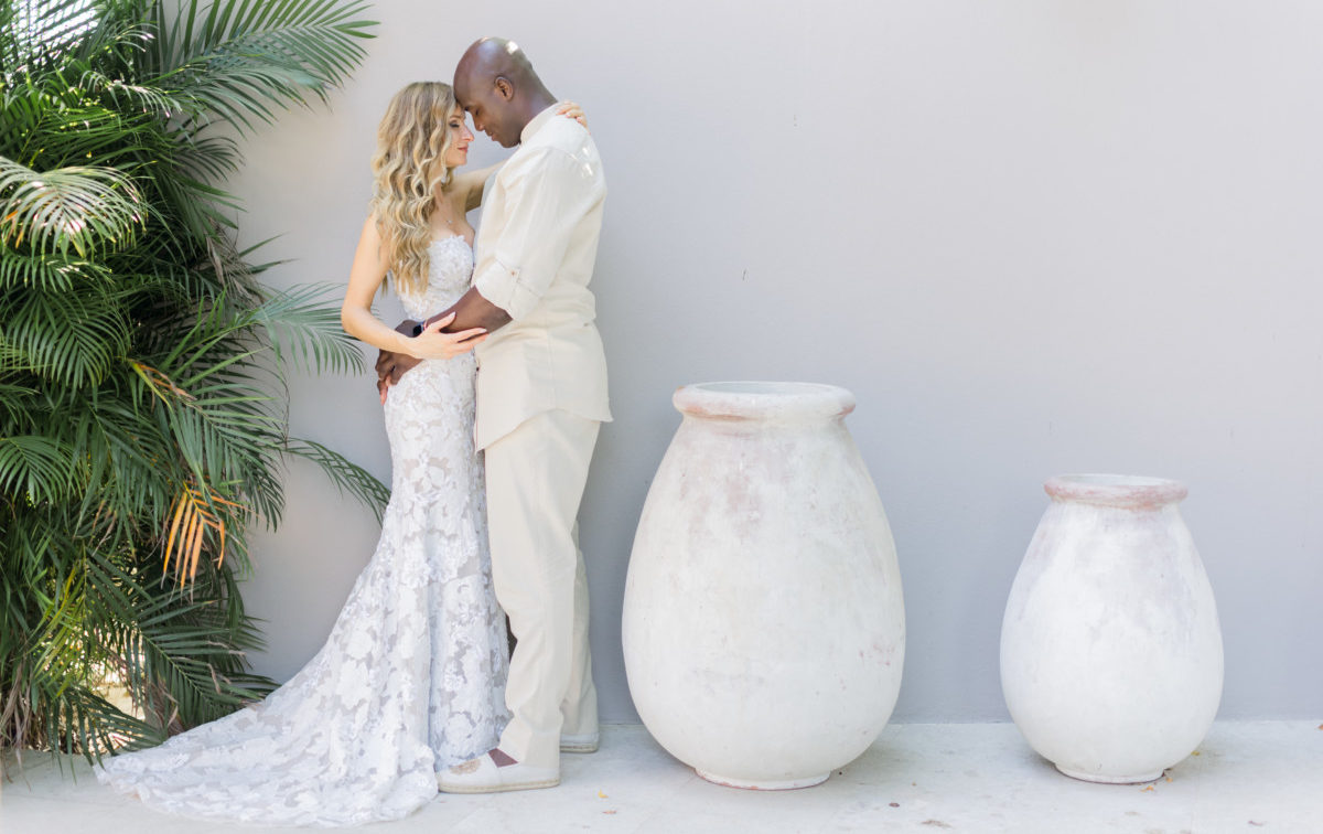 Bride and Groom stand next to oversize vases and palms for their destination wedding -Punta Mita Mexico Four Seasons hotel